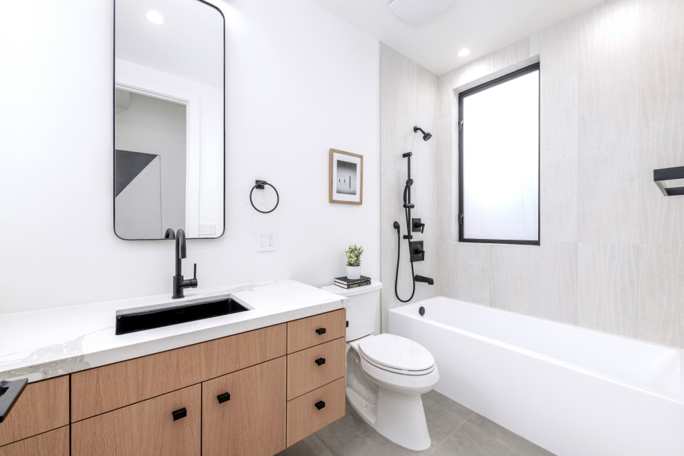 This is an example of a mid-sized modern kids bathroom in San Francisco with flat-panel cabinets, an alcove tub, gray tile, porcelain tile, porcelain floors, an undermount sink, engineered quartz benchtops, white benchtops, a single vanity and a floating vanity.