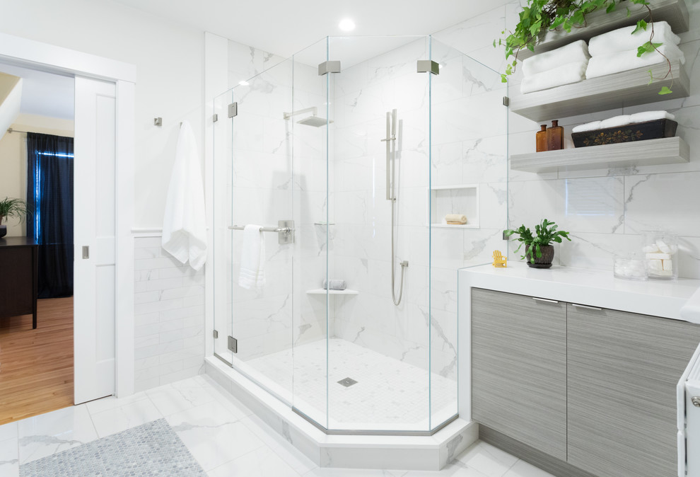 Transitional bathroom in Boston with flat-panel cabinets, grey cabinets, a corner shower, white tile, white walls, white floor and a hinged shower door.