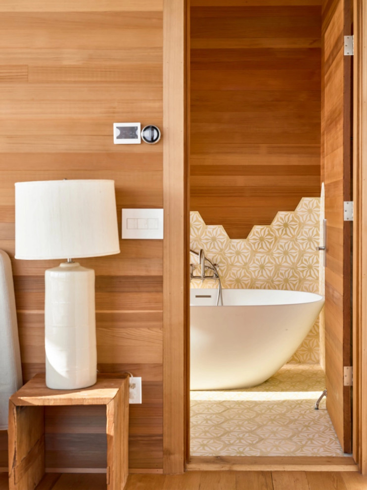 Beach style bathroom in Providence with multi-coloured tile, medium hardwood floors, brown floor and wood walls.