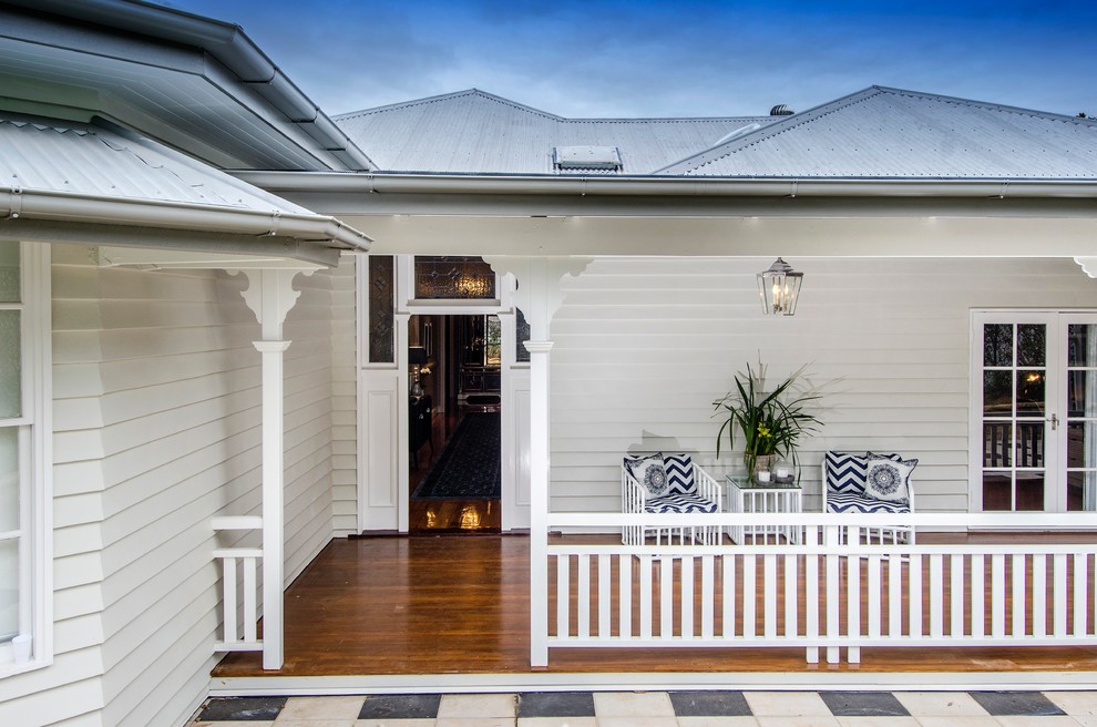 This is an example of a mid-sized beach style deck in Brisbane with a roof extension.