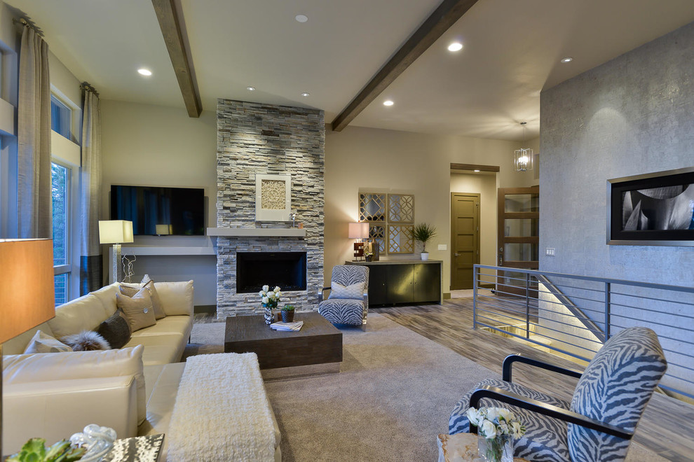 Design ideas for a mid-sized contemporary open concept family room in Denver with grey walls, medium hardwood floors, a standard fireplace, a stone fireplace surround, a wall-mounted tv and brown floor.