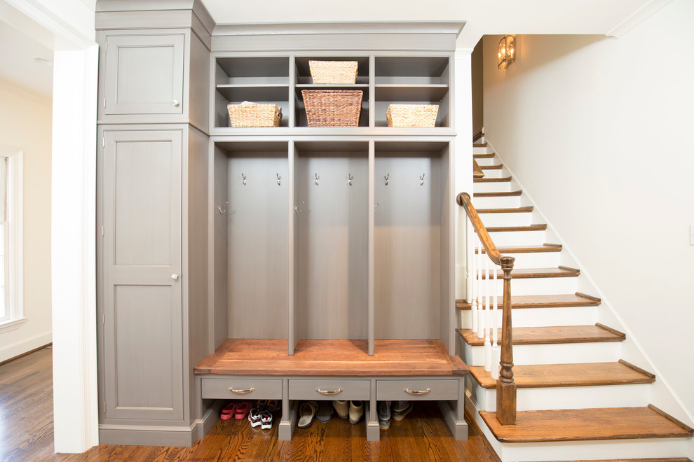 Inspiration for a mid-sized transitional medium tone wood floor and brown floor mudroom remodel with white walls