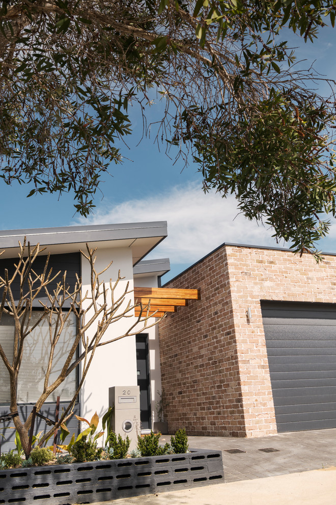 This is an example of a mid-sized contemporary one-storey brick multi-coloured house exterior in Perth with a flat roof and a metal roof.