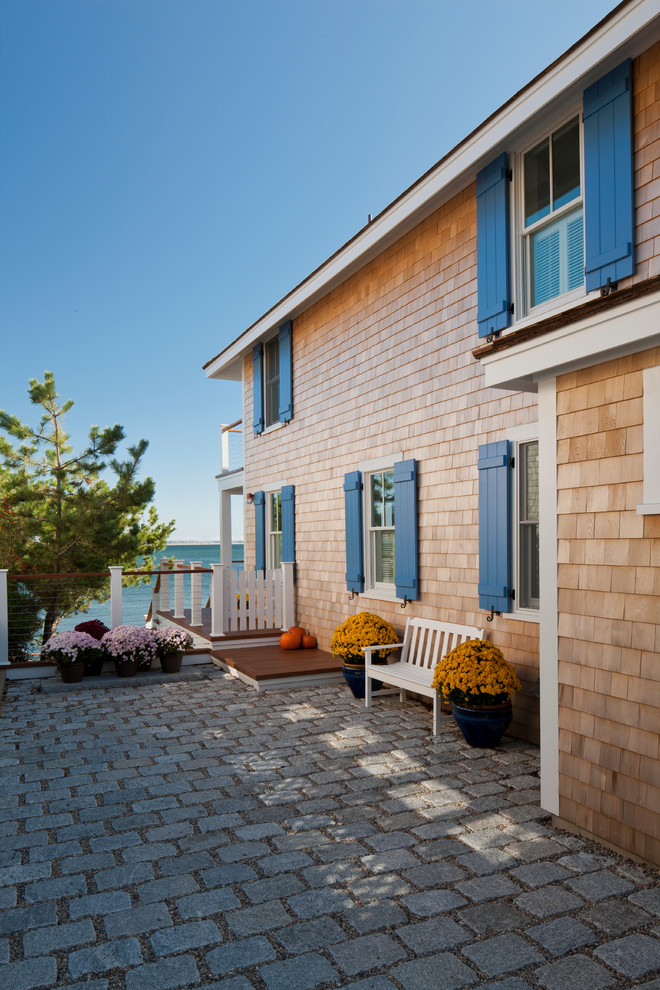 This is an example of a large beach style two-storey beige exterior in Boston with wood siding and a gable roof.