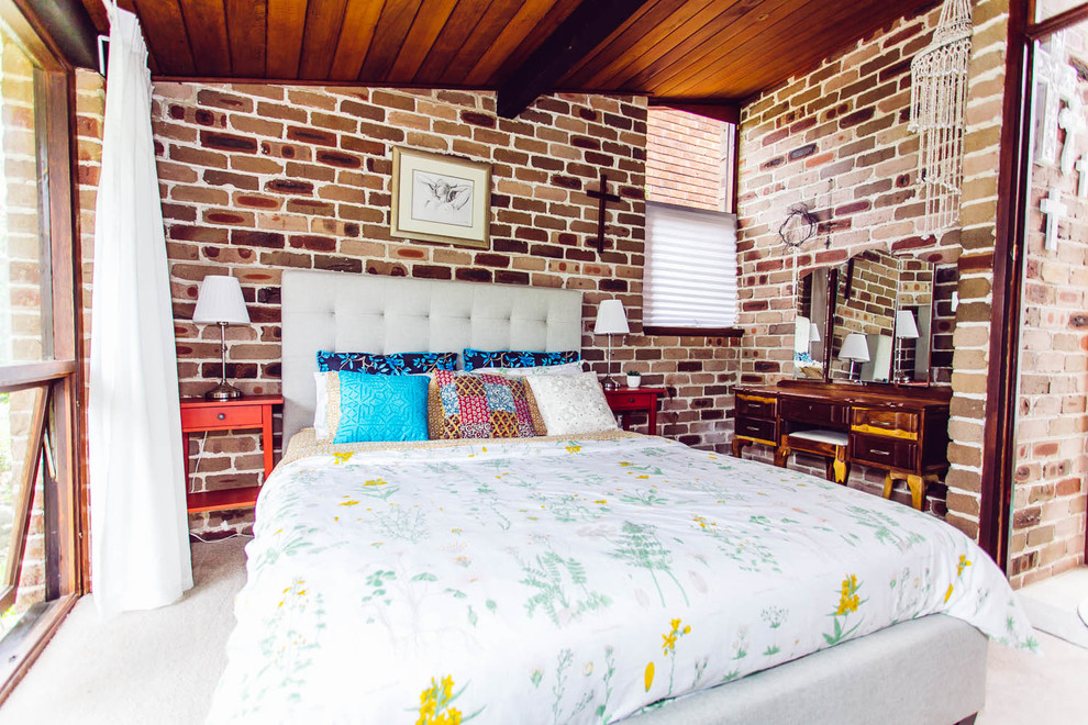 Photo of a small tropical master bedroom in Sydney with brown walls, carpet and no fireplace.