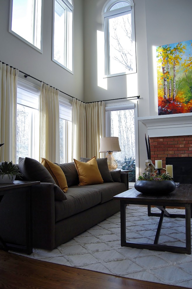 Inspiration for a large transitional loft-style living room in Vancouver with grey walls, medium hardwood floors, a standard fireplace, a brick fireplace surround and no tv.