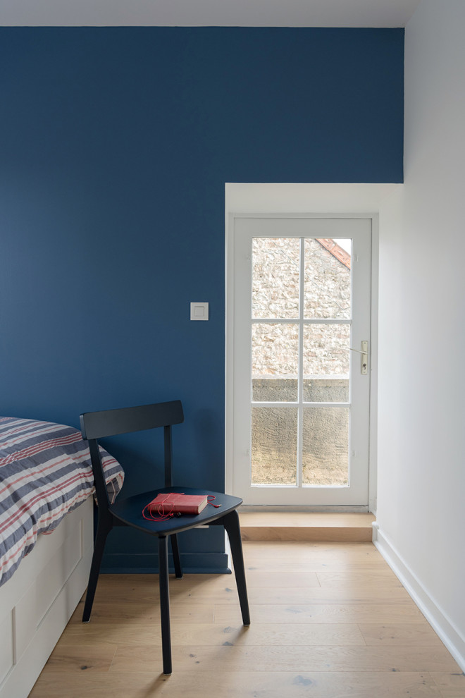 Inspiration för mellanstora lantliga sovrum, med blå väggar och ljust trägolv
