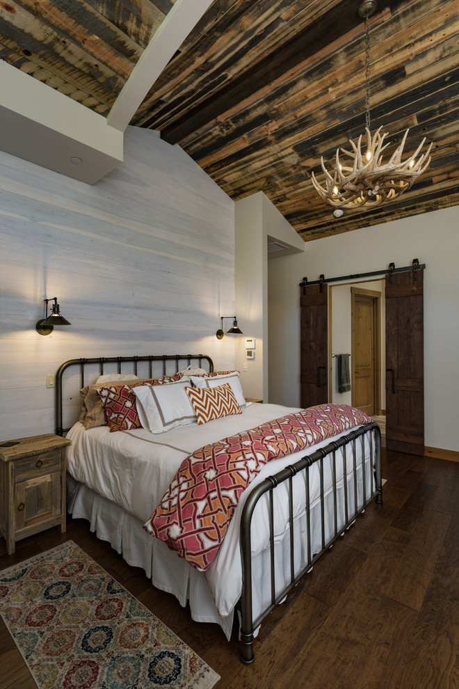Large country master bedroom in Albuquerque with white walls, medium hardwood floors and brown floor.