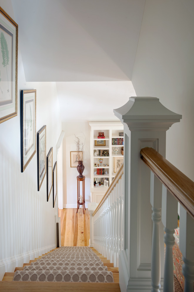 Large traditional carpeted straight staircase in Charleston with carpet risers.