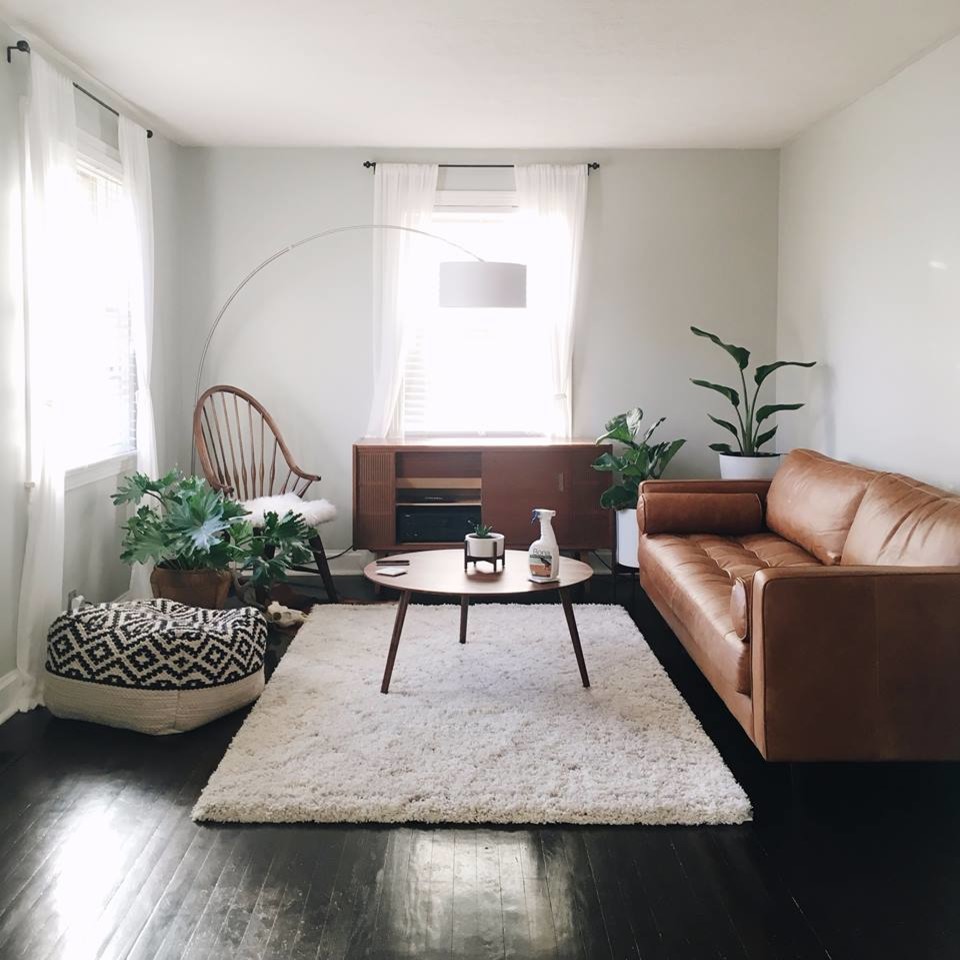 Photo of a mid-sized midcentury formal open concept living room in Philadelphia with white walls, painted wood floors, no fireplace, no tv and black floor.