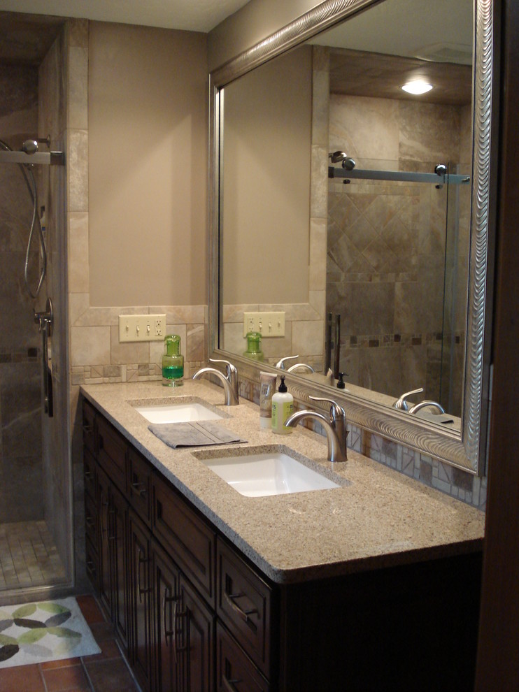 This is an example of a mid-sized traditional master bathroom in Other with an undermount sink, recessed-panel cabinets, medium wood cabinets, engineered quartz benchtops, an alcove shower, a two-piece toilet, gray tile, porcelain tile, grey walls and porcelain floors.