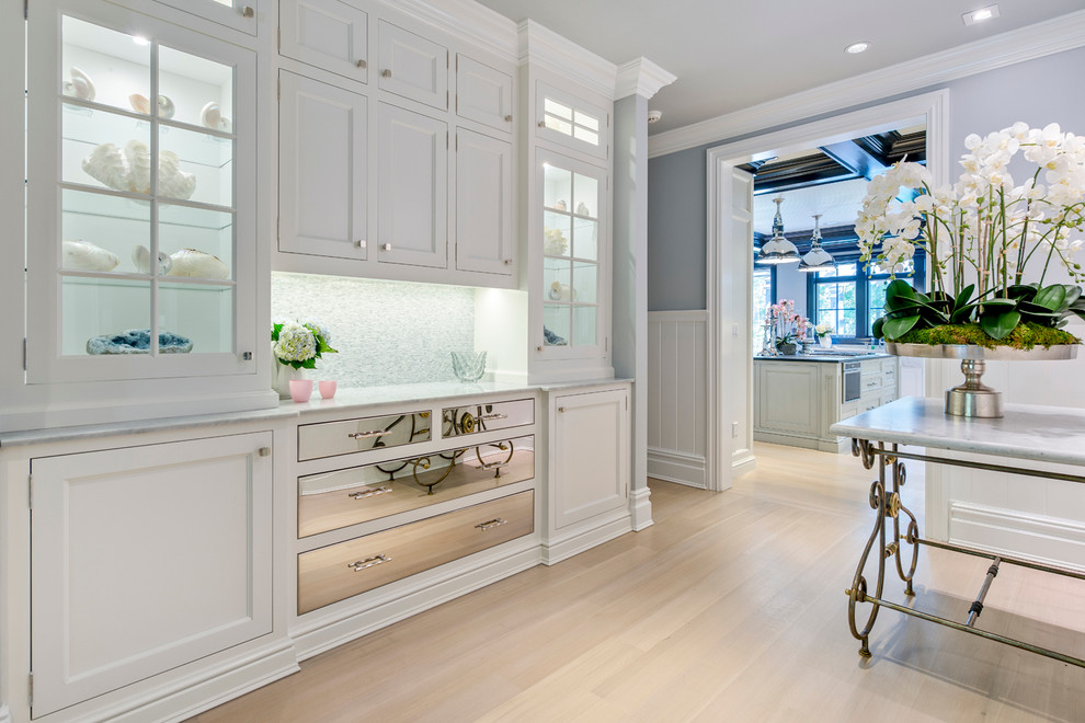Inspiration for a small beach style galley separate kitchen in New York with shaker cabinets, white cabinets, stainless steel appliances, light hardwood floors, quartz benchtops, grey splashback, stone tile splashback and with island.