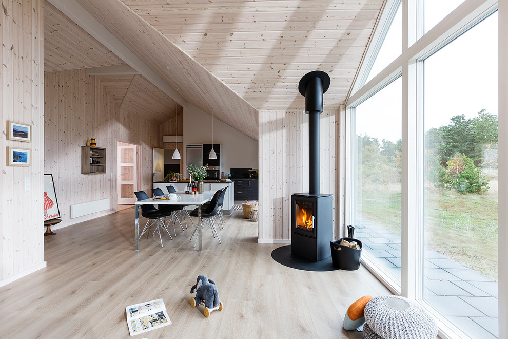 Inspiration for a mid-sized scandinavian formal open concept living room in Aarhus with light hardwood floors, beige walls and a wood stove.