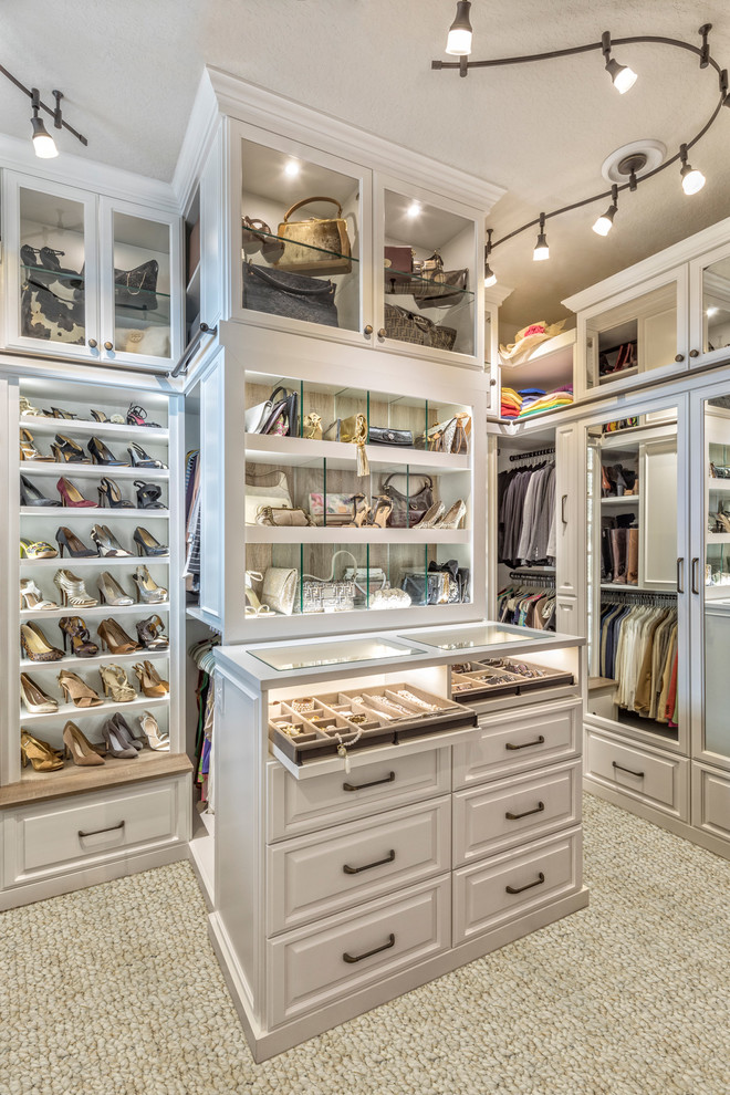 Design ideas for a large women's dressing room in Orlando with raised-panel cabinets, white cabinets, carpet and beige floor.