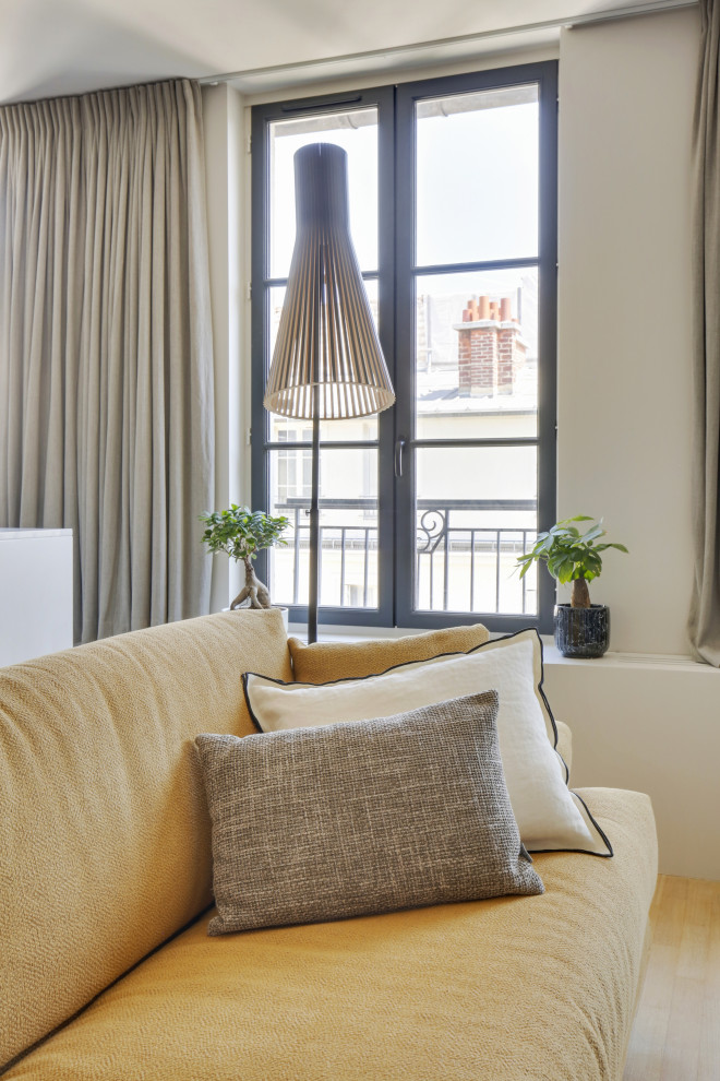 Mid-sized contemporary master bedroom in Paris with beige walls, light hardwood floors, beige floor and wallpaper.