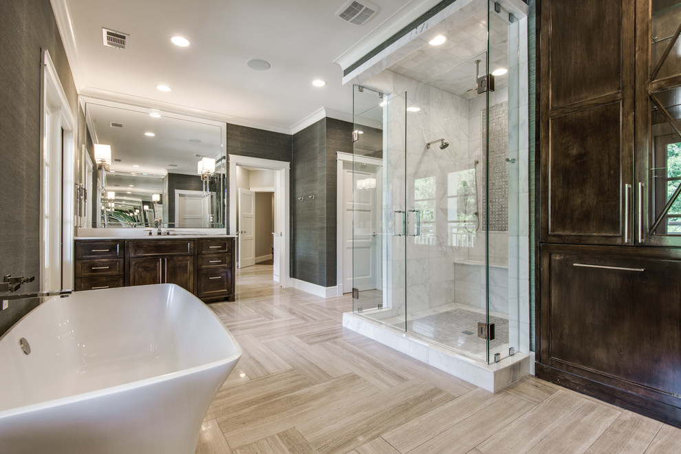 Photo of a large transitional master bathroom in Dallas with recessed-panel cabinets, dark wood cabinets, a freestanding tub, an alcove shower, gray tile, marble, green walls, light hardwood floors, beige floor and a hinged shower door.