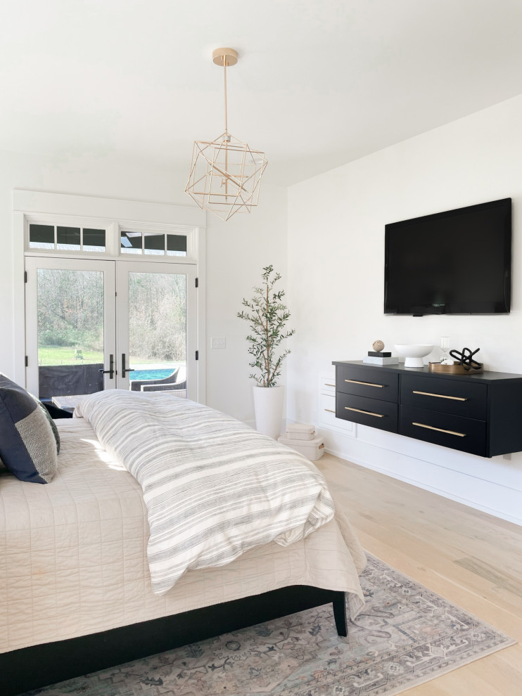 Photo of a large modern master bedroom in Nashville with white walls, light hardwood flooring and beige floors.