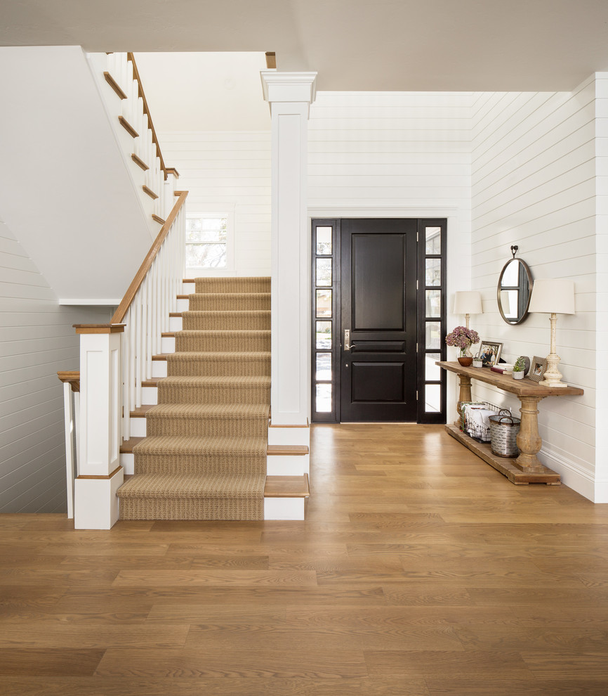 Design ideas for a country foyer in Salt Lake City with white walls, medium hardwood floors, a single front door, a black front door and brown floor.