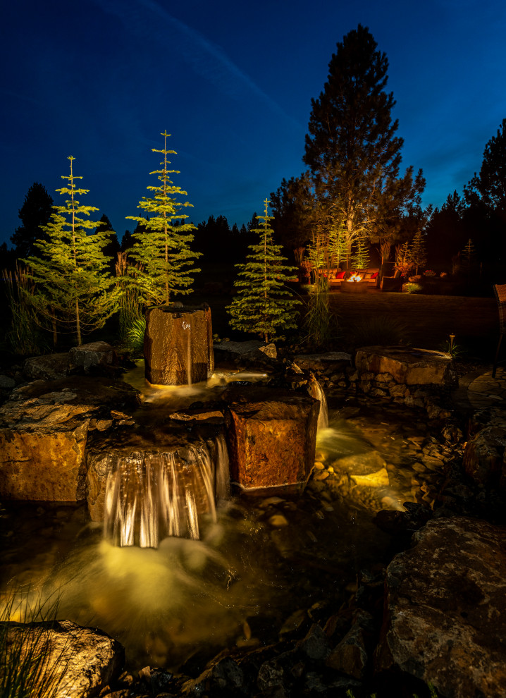 This is an example of a large traditional backyard full sun garden in Seattle with with waterfall and natural stone pavers.