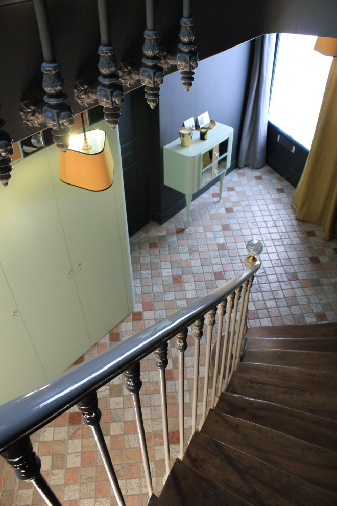 Идея дизайна: изогнутая лестница среднего размера в стиле неоклассика (современная классика) с деревянными ступенями, крашенными деревянными подступенками, металлическими перилами и кладовкой или шкафом под ней