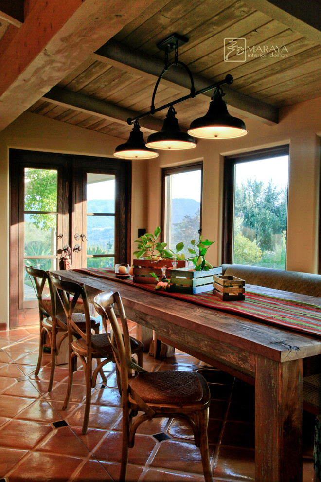 Photo of a mid-sized country dining room in Santa Barbara with white walls, terra-cotta floors and no fireplace.
