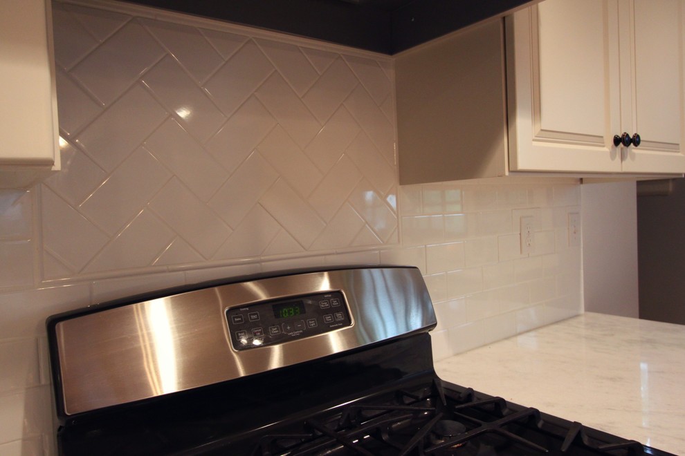 Inspiration for a mid-sized transitional medium tone wood floor eat-in kitchen remodel in Omaha with a drop-in sink, raised-panel cabinets, white cabinets, quartzite countertops, white backsplash, subway tile backsplash, stainless steel appliances and an island