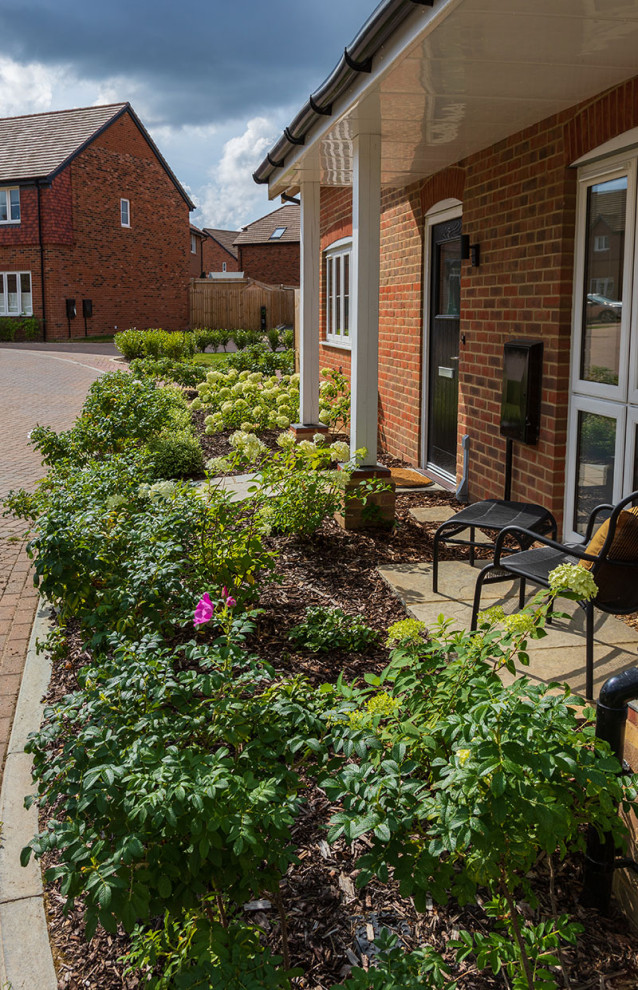 Idee per una piccola aiuola country esposta in pieno sole davanti casa in estate con pavimentazioni in pietra naturale