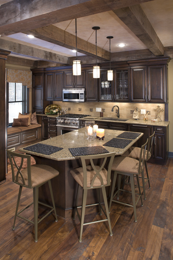 Photo of a large traditional single-wall eat-in kitchen in Minneapolis with with island, an undermount sink, raised-panel cabinets, dark wood cabinets, stainless steel appliances and medium hardwood floors.
