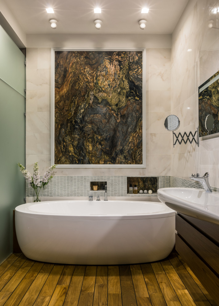 Inspiration for a large contemporary master wet room bathroom in Moscow with raised-panel cabinets, dark wood cabinets, a freestanding tub, a wall-mount toilet, pink tile, marble, pink walls, medium hardwood floors, a wall-mount sink, green floor, a hinged shower door and white benchtops.