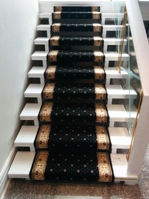 Photo of a large traditional carpeted floating staircase in Toronto with glass railing and open risers.