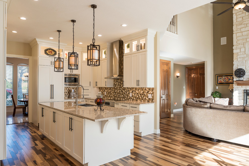 Example of a mid-sized transitional galley light wood floor kitchen pantry design in Dallas with an undermount sink, shaker cabinets, white cabinets, granite countertops, beige backsplash, ceramic backsplash, stainless steel appliances and an island