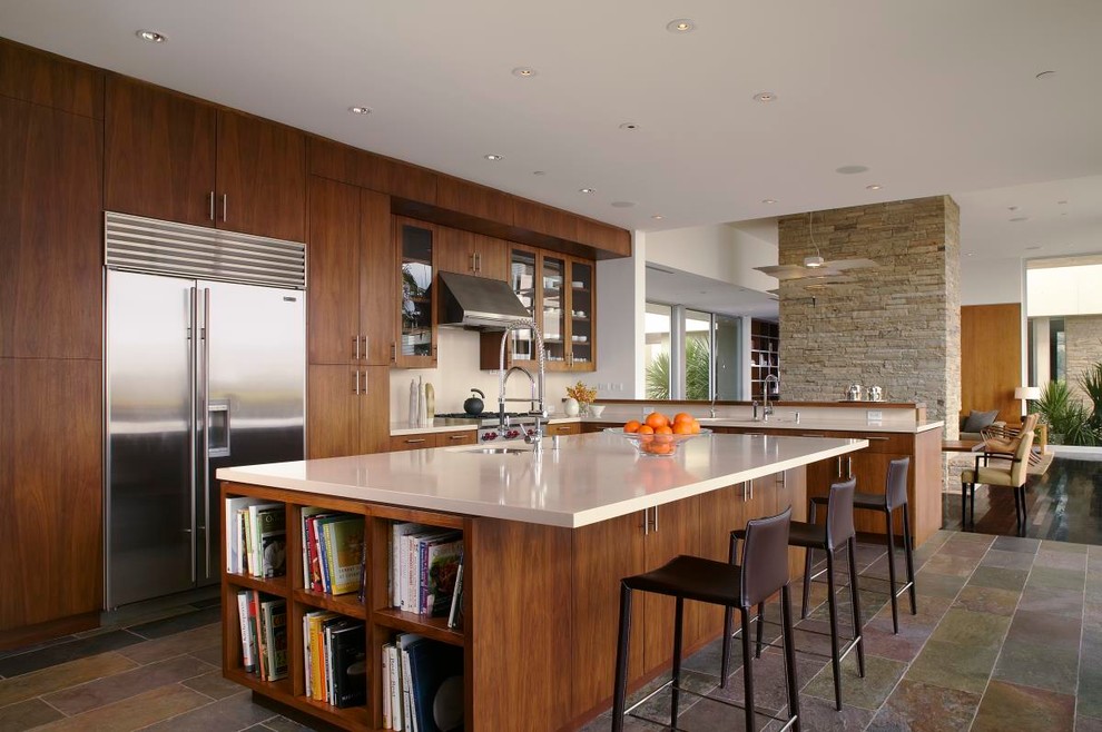Modern l-shaped open plan kitchen in Los Angeles with an undermount sink, flat-panel cabinets, medium wood cabinets, quartzite benchtops, white splashback, stone slab splashback, stainless steel appliances, porcelain floors and with island.