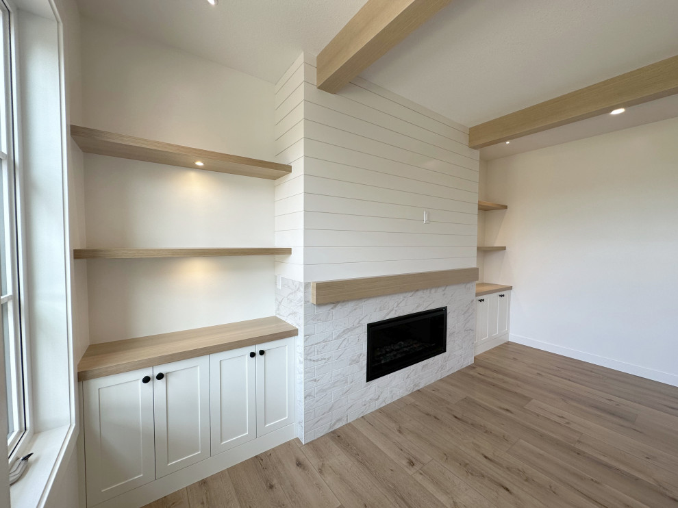 他の地域にあるカントリー風のおしゃれなLDK (白い壁、クッションフロア、標準型暖炉、タイルの暖炉まわり、埋込式メディアウォール、ベージュの床、表し梁、塗装板張りの壁) の写真