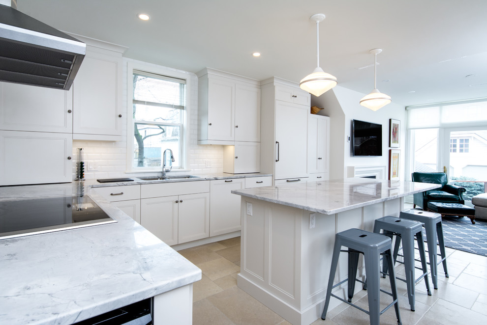 Photo of a mid-sized transitional l-shaped eat-in kitchen in Toronto with an undermount sink, shaker cabinets, white cabinets, marble benchtops, white splashback, subway tile splashback, stainless steel appliances, cement tiles and with island.
