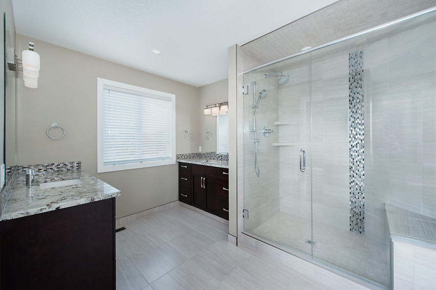 Large transitional master gray tile and porcelain tile porcelain tile freestanding bathtub photo in Calgary with an undermount sink, granite countertops, dark wood cabinets and beige walls