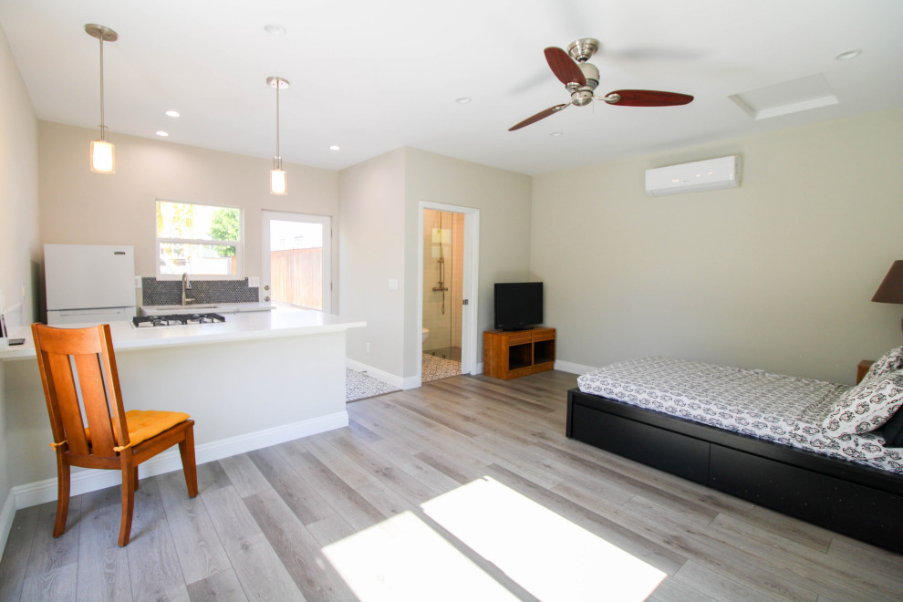 Mittelgroßes Modernes Wohnzimmer im Loft-Stil mit beiger Wandfarbe, hellem Holzboden, Eck-TV und braunem Boden in Los Angeles