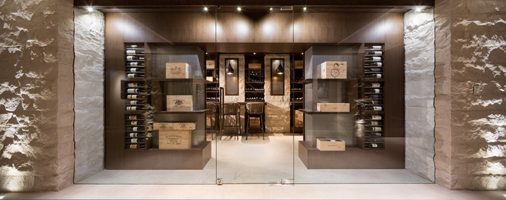 This is an example of a large contemporary wine cellar in Vancouver with light hardwood floors and display racks.