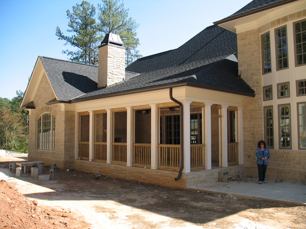 This is an example of an expansive mediterranean two-storey white house exterior in Atlanta with stone veneer, a gable roof and a shingle roof.