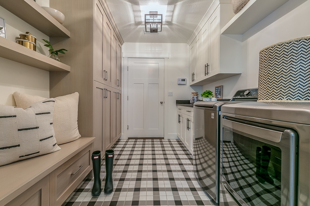 Inspiration for a mid-sized midcentury galley dedicated laundry room in Toronto with raised-panel cabinets, light wood cabinets, quartz benchtops, white walls, ceramic floors, a side-by-side washer and dryer, white floor and black benchtop.