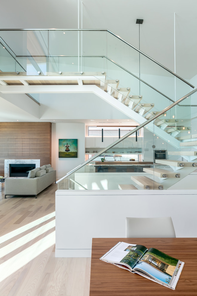 Expansive contemporary wood floating staircase in Tampa with open risers and glass railing.
