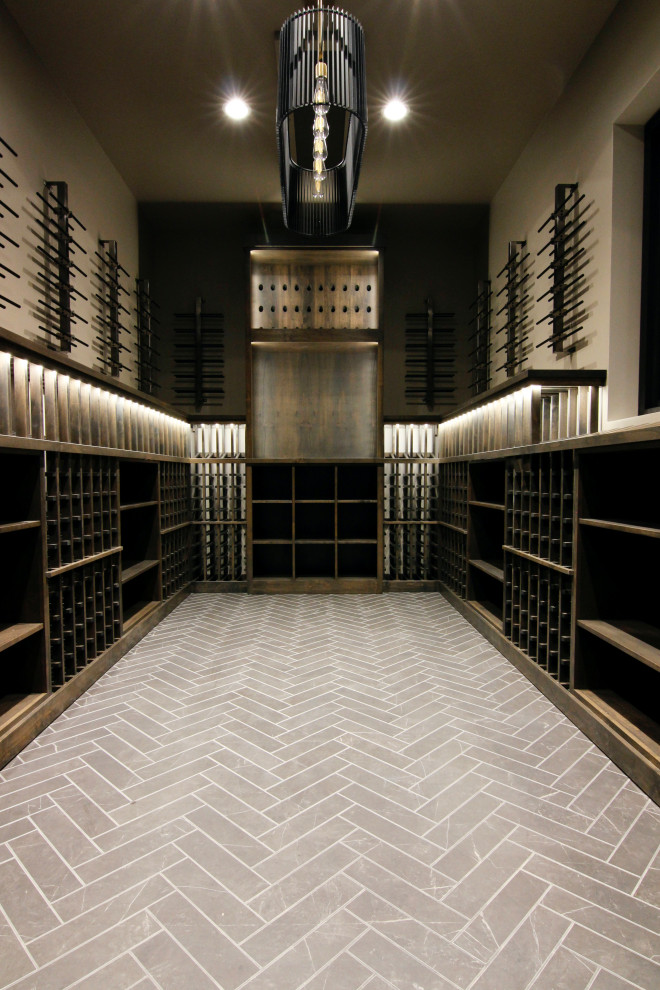 Réalisation d'une grande cave à vin minimaliste avec un sol en carrelage de céramique, des casiers et un sol beige.