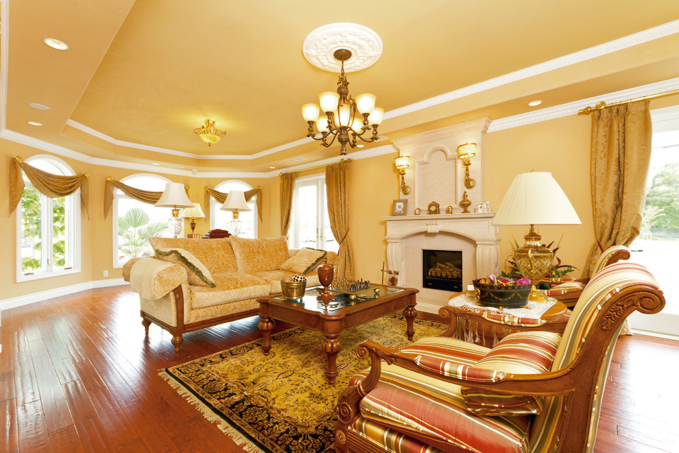 Inspiration for a traditional living room in Other with yellow walls, painted wood floors and brown floor.