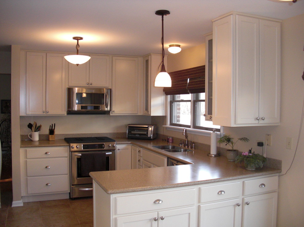 Photo of a small traditional u-shaped eat-in kitchen in Chicago with an undermount sink, white cabinets, granite benchtops, stainless steel appliances, ceramic floors, no island and shaker cabinets.