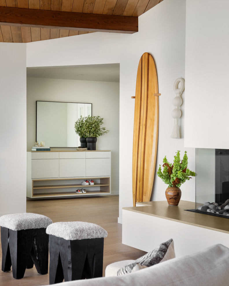 This is an example of a scandinavian living room in San Francisco with white walls and a wood ceiling.
