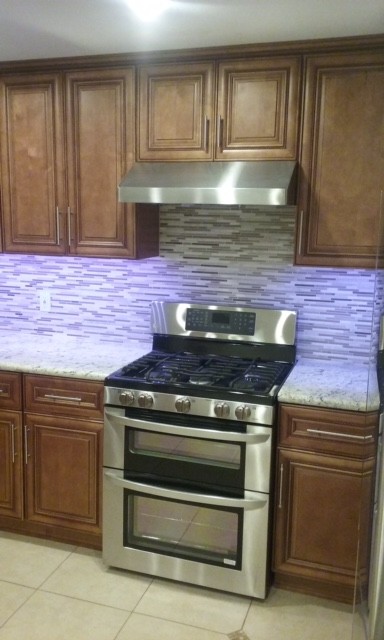 Example of a mid-sized transitional u-shaped ceramic tile eat-in kitchen design in Orange County with raised-panel cabinets, medium tone wood cabinets, multicolored backsplash, matchstick tile backsplash, stainless steel appliances and a peninsula