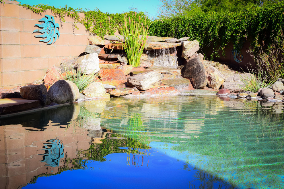 Large backyard kidney-shaped and concrete paver hot tub photo in Phoenix