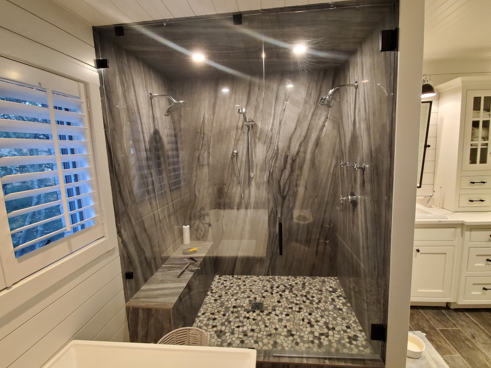 Photo of a large rural ensuite bathroom in Chicago with shaker cabinets, white cabinets, a freestanding bath, an alcove shower, a bidet, white tiles, white walls, wood-effect flooring, a built-in sink, engineered stone worktops, brown floors, a hinged door, white worktops, double sinks, a built in vanity unit, a timber clad ceiling and tongue and groove walls.