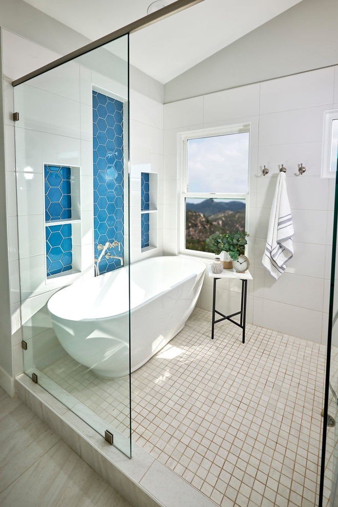 Large modern master wet room bathroom in San Diego with flat-panel cabinets, light wood cabinets, a freestanding tub, a one-piece toilet, blue tile, glass tile, white walls, porcelain floors, an undermount sink, engineered quartz benchtops, white floor, a hinged shower door and white benchtops.