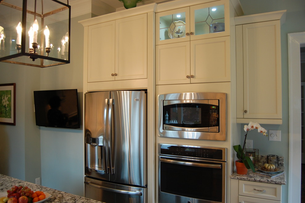 Inspiration for a transitional u-shaped eat-in kitchen remodel in Raleigh with an undermount sink, recessed-panel cabinets, white cabinets, quartzite countertops, white backsplash, subway tile backsplash and stainless steel appliances