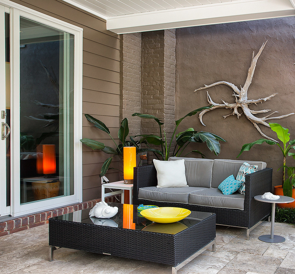 This is an example of a contemporary patio in Richmond with natural stone pavers and a roof extension.